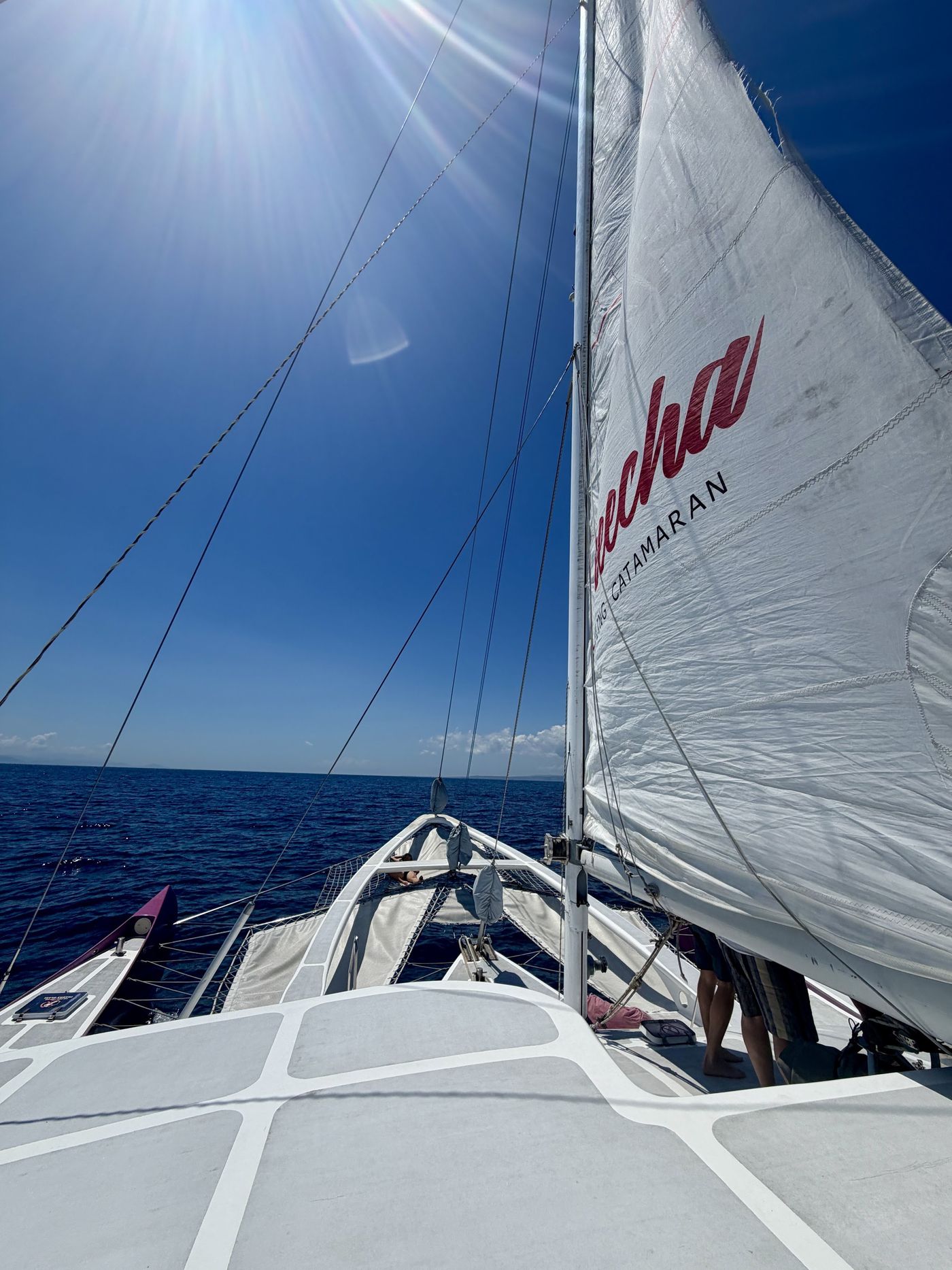 A catamaran under full sail on open water off Bali